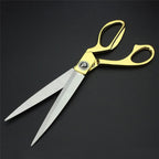 Stylish gold-plated professional cloth cutting scissors against a neutral background.