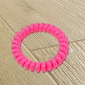 A bulk pack of 100 multi-colored telephone wire hair bands.