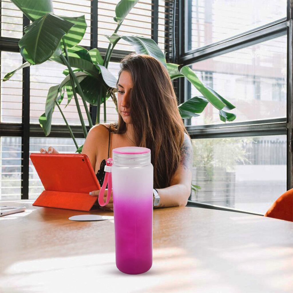 Person holding a portable motivational glass water bottle, ideal for on-the-go use.
