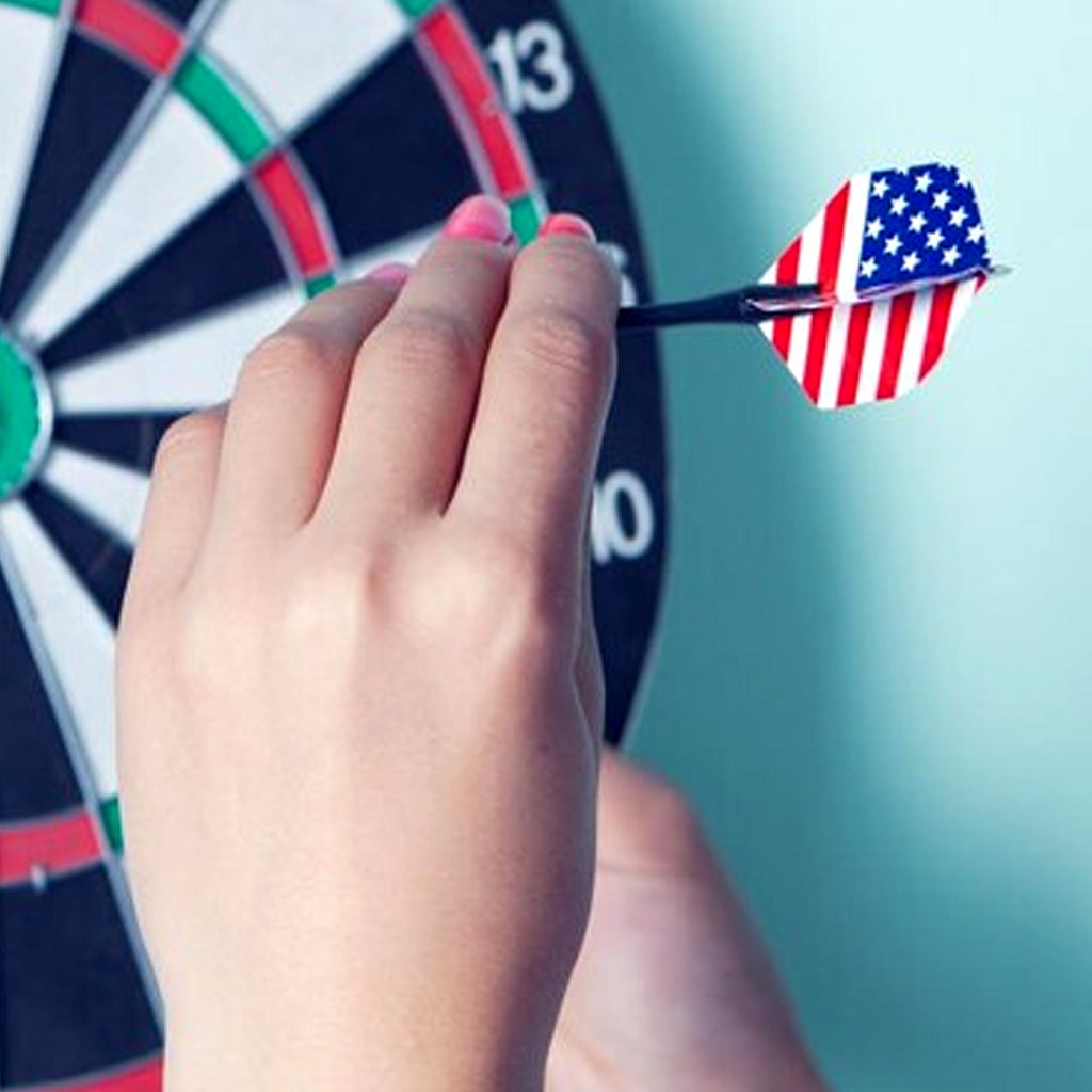 A person holding a steel tip dart, ready to throw at a dartboard.