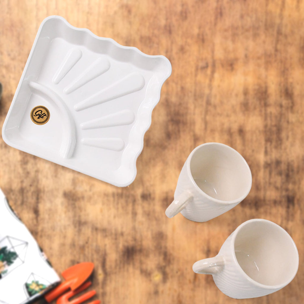 Two ceramic tea cups displayed alongside square plastic platter for serving