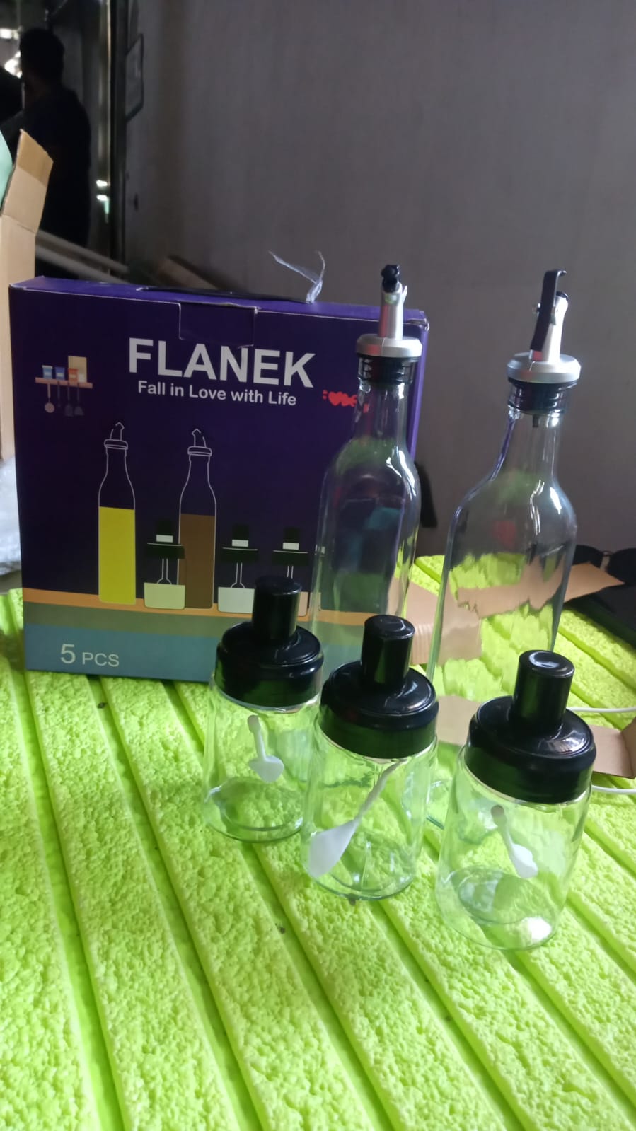 Stylish glass oil dispenser and spice jar set complementing a kitchen decor.
