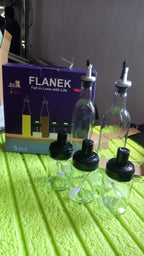Stylish glass oil dispenser and spice jar set complementing a kitchen decor.