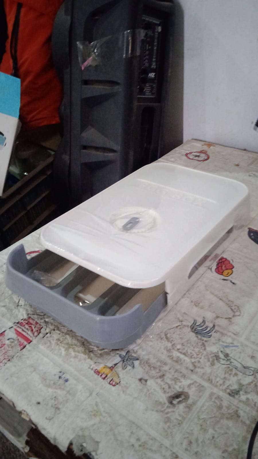 The egg storage box neatly placed inside a refrigerator, optimizing space with its stackable design.