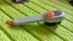 Angled view of the scrubbing brush with dispenser, highlighting its design.