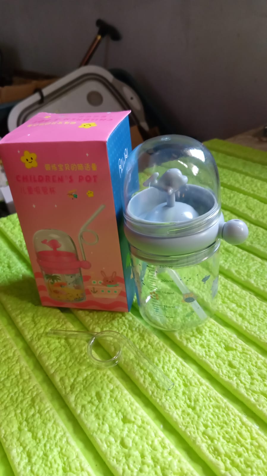 Lifestyle shot of the Whale Spray Sippy Cup being used outdoors by a happy toddler.