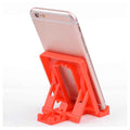 A sturdy black plastic bulk mobile phone stand from the 50-piece set, holding a smartphone upright on a desk.