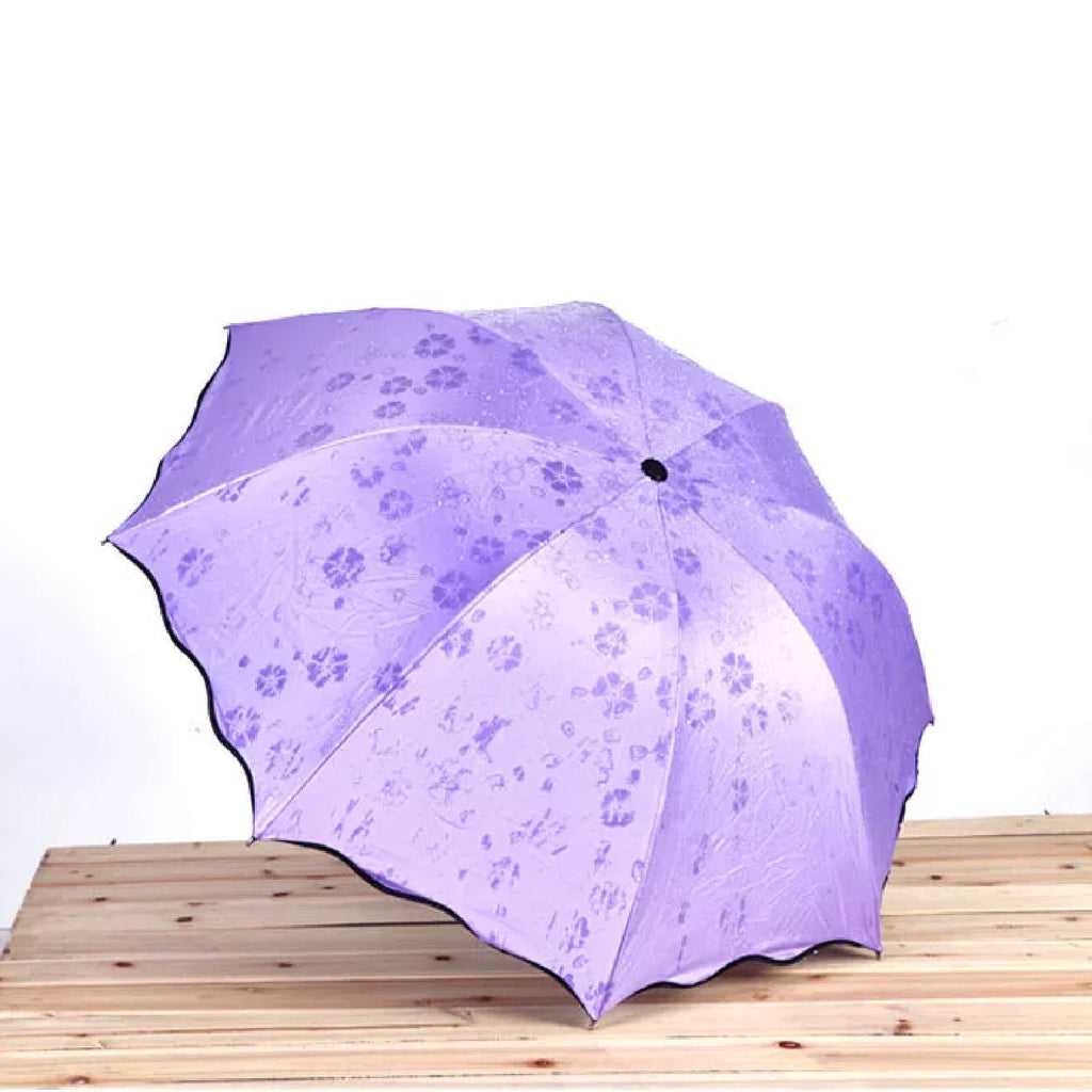 Person holding a wet Magic Umbrella with visible color-changing blossom design.