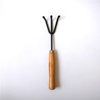 Gardener holding the hand cultivator, demonstrating comfortable grip.
