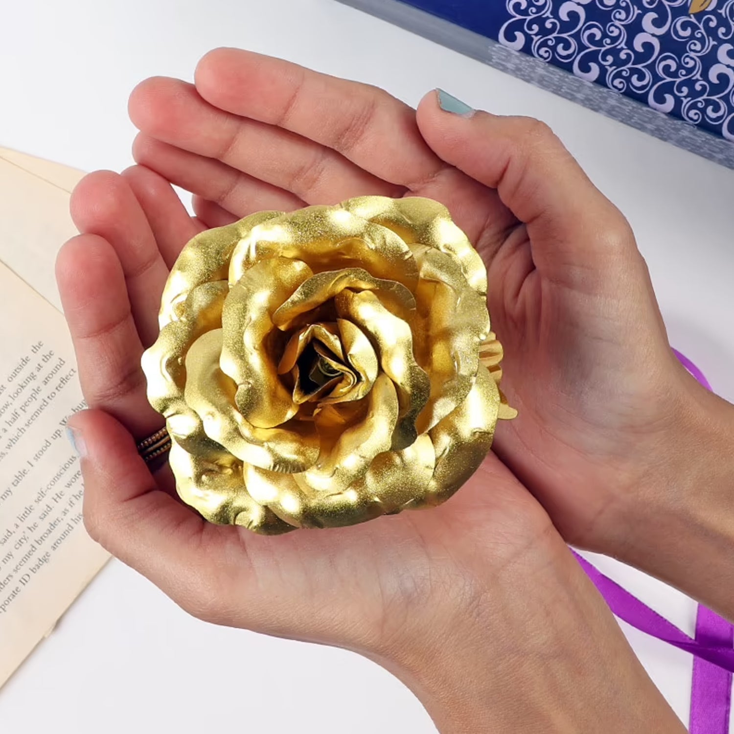 Hand holding a beautiful gold plated artificial rose symbolizing everlasting love