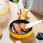 Components of the Electric Egg Boiler Frying Pan including the base, egg holder, and measuring cup.