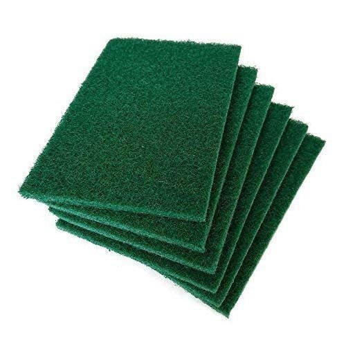 Green cleaning pads effortlessly removing grime from a kitchen tile surface.