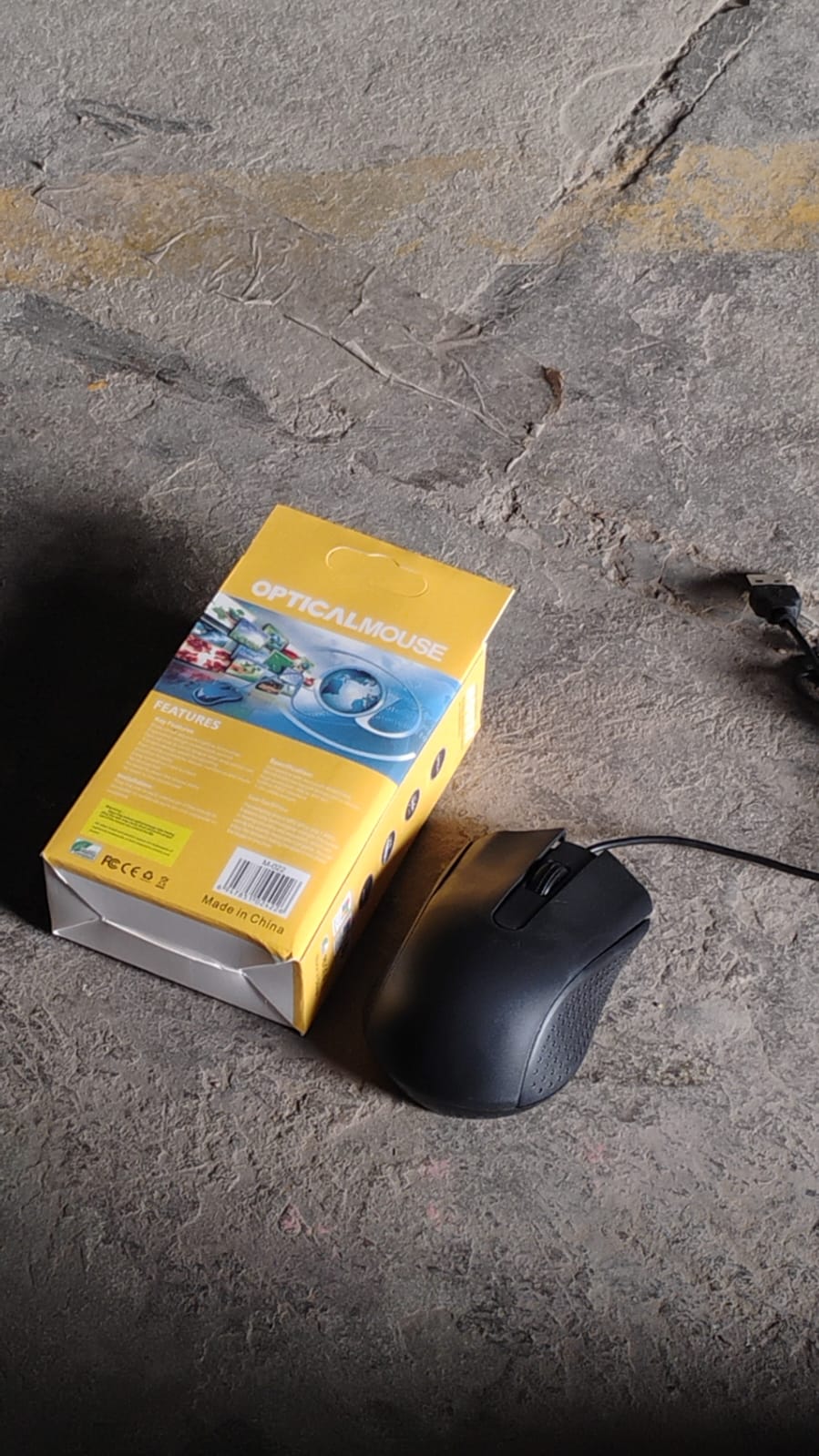 Angled view of the Compshop M-022 Wired Optical Mouse with its connected USB cable.