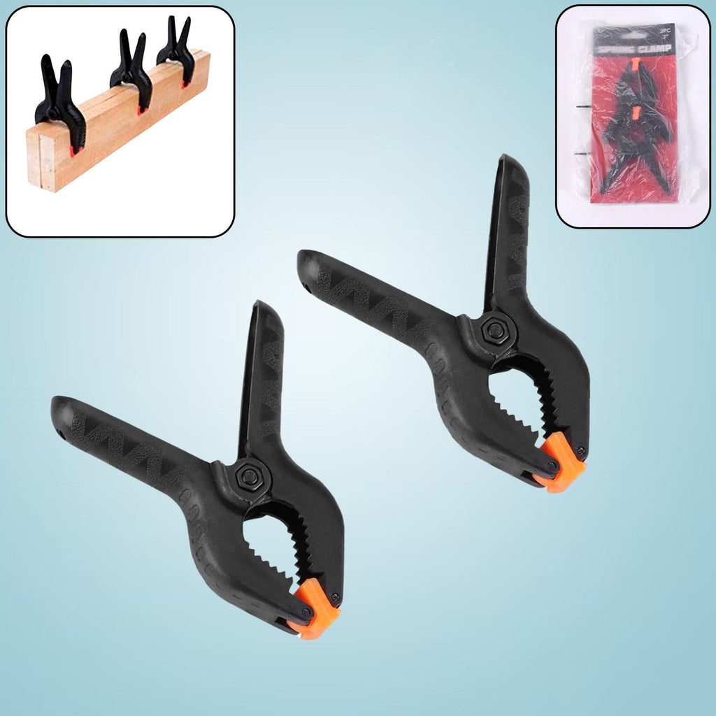 Close-up of a pair of heavy-duty spring clamps for mobile device screen repair.
