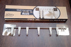 A functional stainless steel utensil hanger rail installed in a modern kitchen, with cooking utensils hanging.