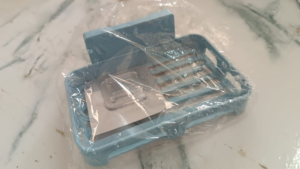 The versatile self-adhesive soap holder securely placed on a smooth ceramic tile wall.