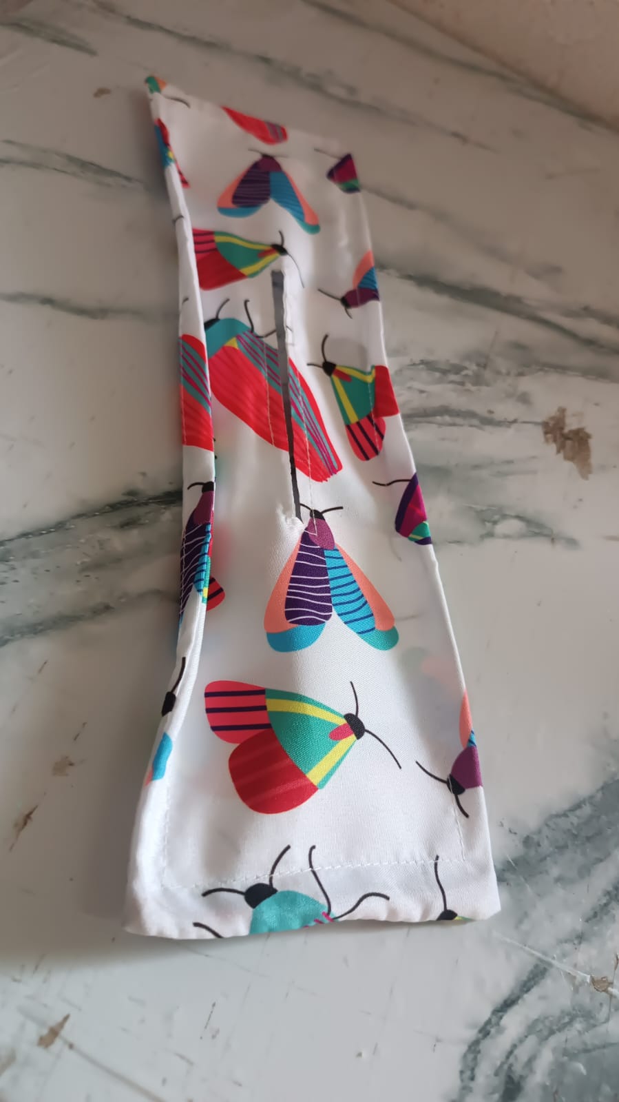 Knotted Wire Headband with an abstract print, displayed neatly on a wooden surface.