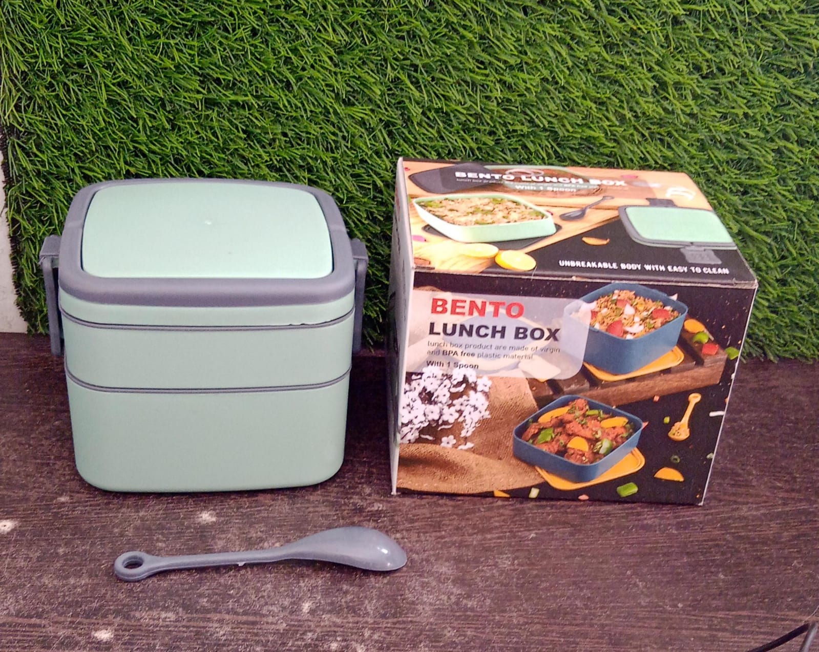 The green stackable tiffin box displayed with its matching spoon.