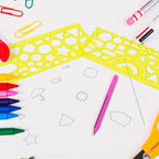 Student using a clear template ruler to draw accurate geometric shapes on paper.