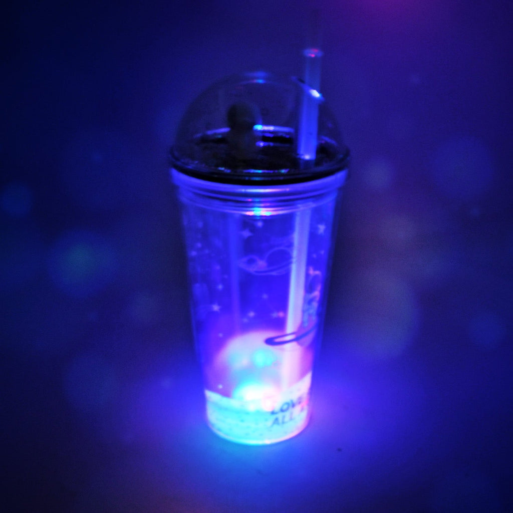 Side view of the plastic astronaut tumbler with its LED base illuminated, perfect for kids.