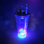 Side view of the plastic astronaut tumbler with its LED base illuminated, perfect for kids.