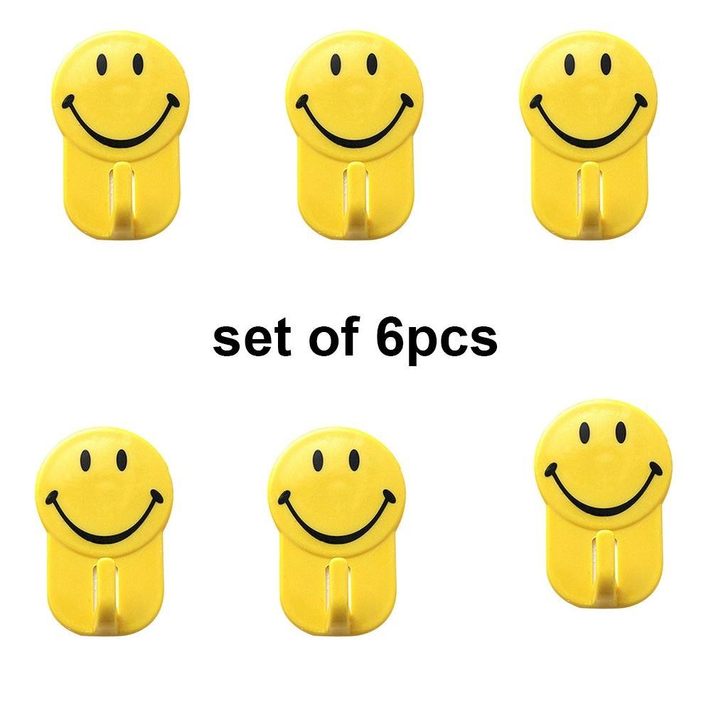 Multiple colorful smiley face hooks arranged neatly on a smooth surface.