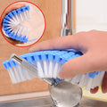 Flexible cleaning brush bent for scrubbing kitchen sink corners.