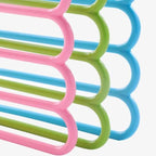 Set of assorted colour 5-layer space saving hangers stacked for compact storage.
