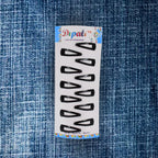 A single matt black Metal Tic Tac Hair Clip demonstrating its strong, flexible mechanism.
