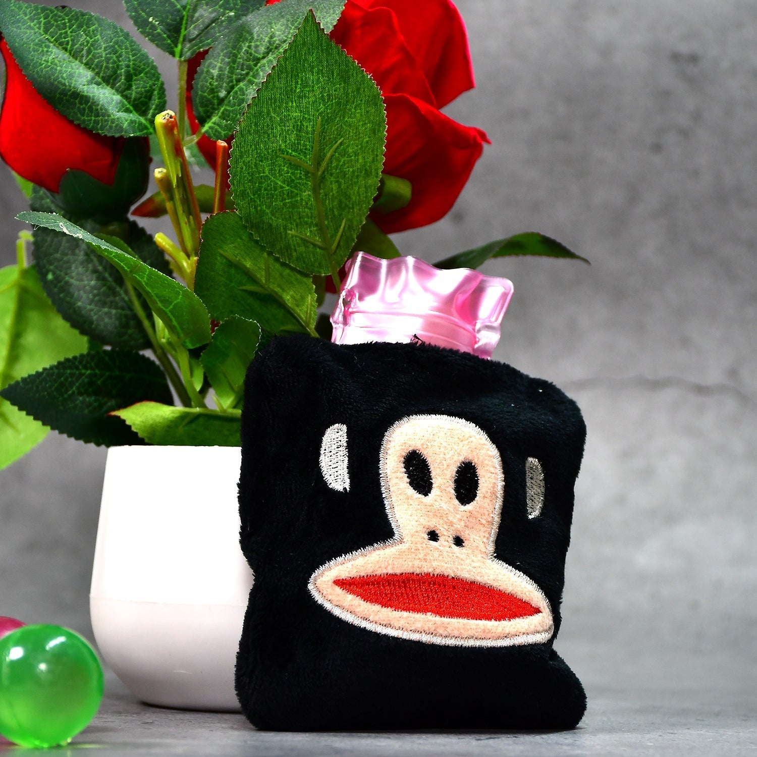 Mini hot water bag with a fun emoji cover displayed frontally.