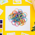 Close-up view of a stretched multicolour rubber band demonstrating its elasticity.