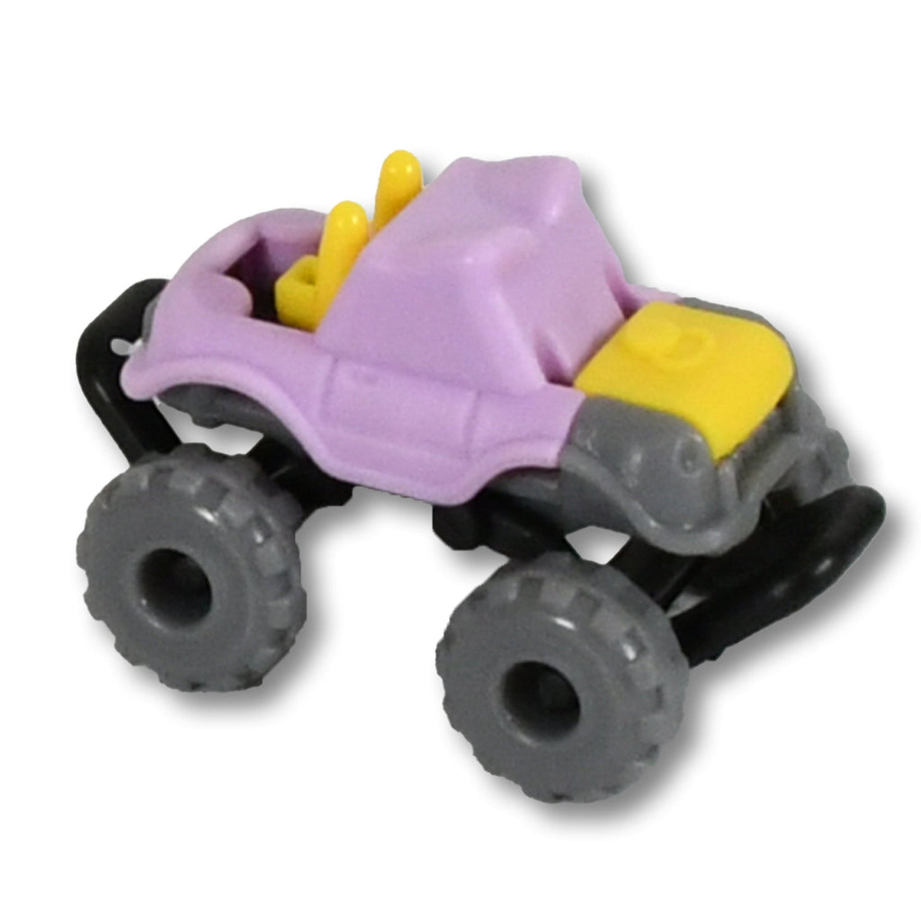 A child's hand playing with one of the mini monster trucks, showing its easy-to-handle size.