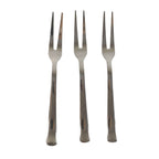 Three small appetizer forks laid out for serving snacks