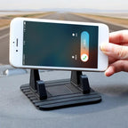 Person watching a video on a smartphone securely placed on the PHOBIA desk phone holder.
