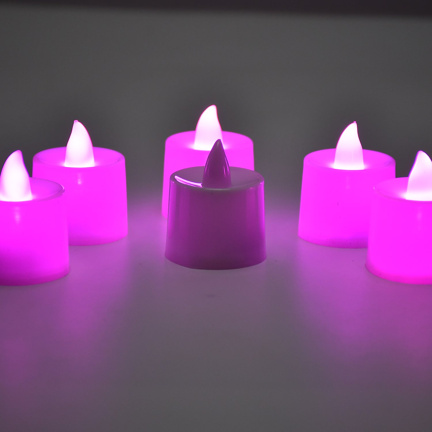 Flameless plastic pink tealight candles offering a warm, ambient glow.