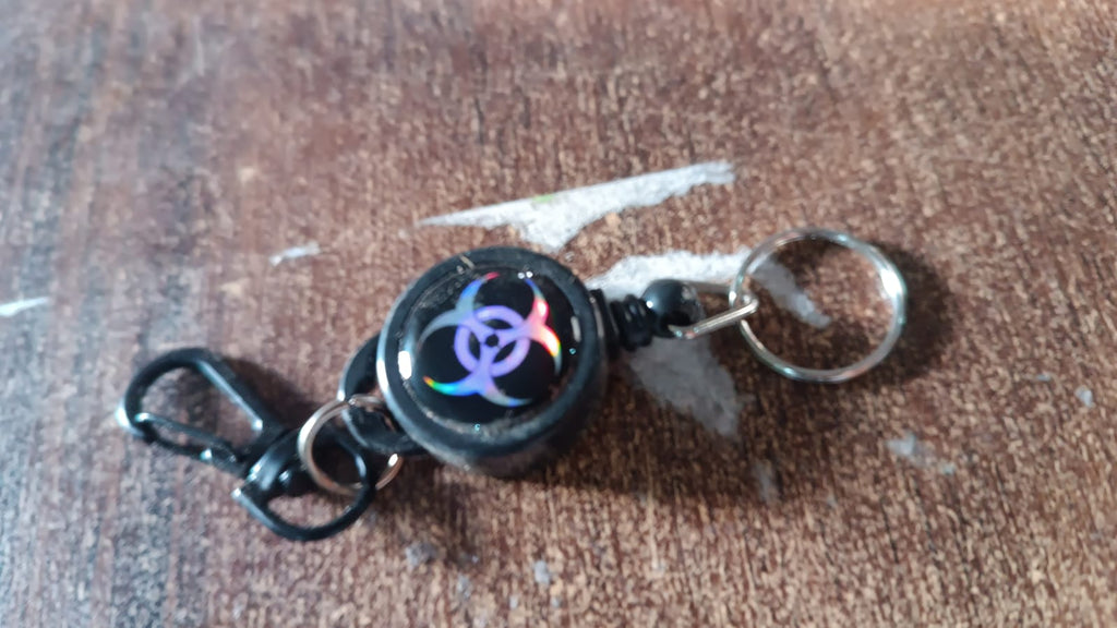 Retractable key chain attached to a belt, ideal for travel and office use.