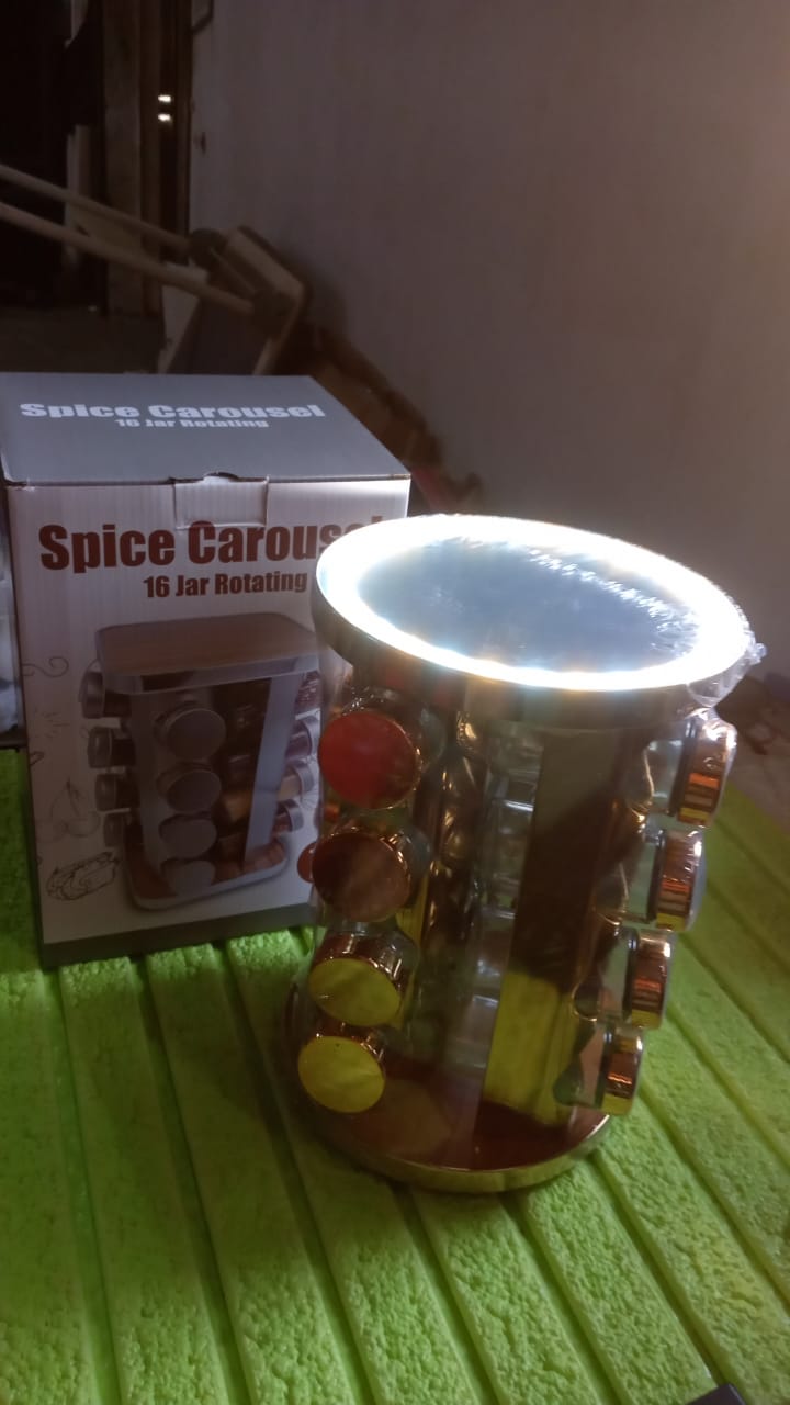 Golden LED spice organizer with 16 jars displayed on a kitchen shelf.