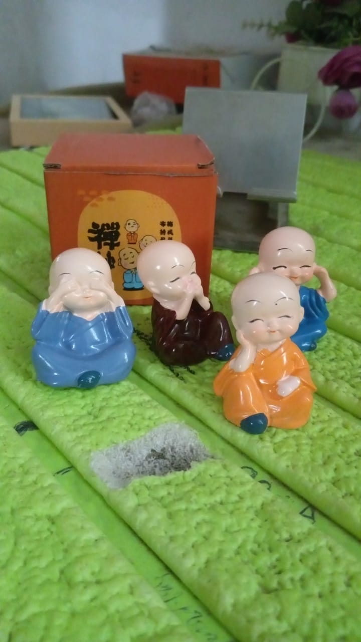4-piece baby Buddha decorative statues arranged on a shelf