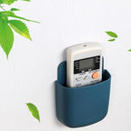A phone charging in a wall mounted holder in a kitchen, keeping the counter clutter-free.
