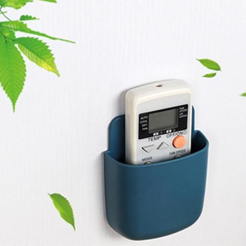 A phone charging in a wall mounted holder in a kitchen, keeping the counter clutter-free.