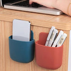 A set of four sleek wall-mounted phone holders arranged on a textured grey wall.