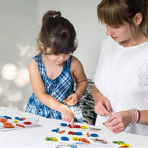Assorted foam magnetic letters in yellow, green, and pink on a plain surface.