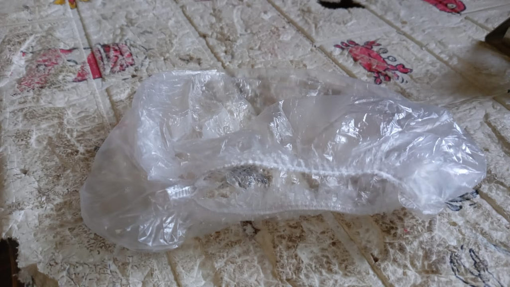 A VelvaBloom disposable shower cap fitted on a mannequin head, showing its universal fit.