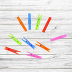 Stack of colourful plastic clothes clips for home and laundry use.