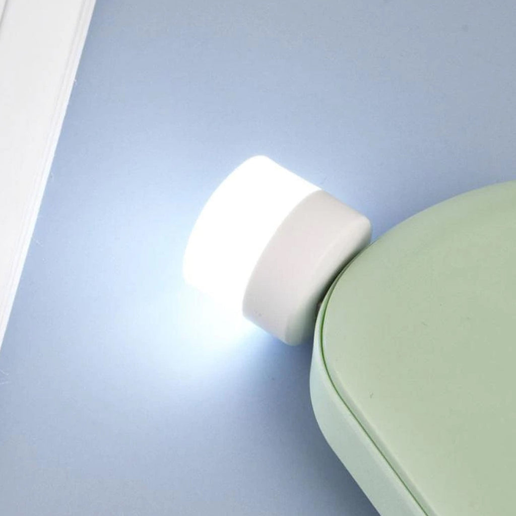 The small USB LED night light shown in hand, highlighting its portability.