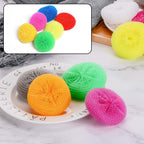 A hand holding a round nylon scrubber, demonstrating its ergonomic design for comfortable utensil cleaning.
