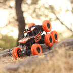 The 8-wheel Rock Climber remote control toy car driving across a rough, uneven surface.