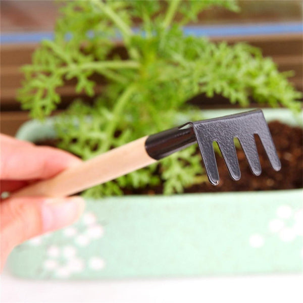 Colorful trowel, shovel, and rake from the Kids Garden Tools Set on a natural background.