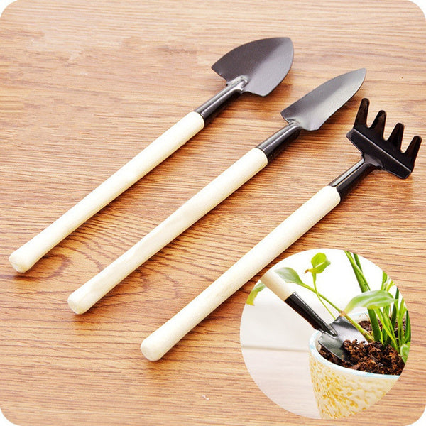 Kids Garden Tools Set of 3 pieces, including a yellow trowel, blue shovel, and green rake.