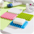 White silicone soap holder with self-draining design for shower use.